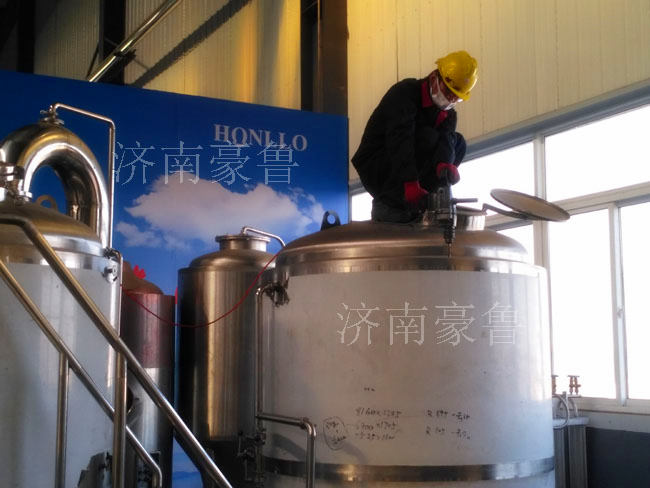 工人在加工啤酒設(shè)備罐體 工人在加工啤酒設(shè)備罐體